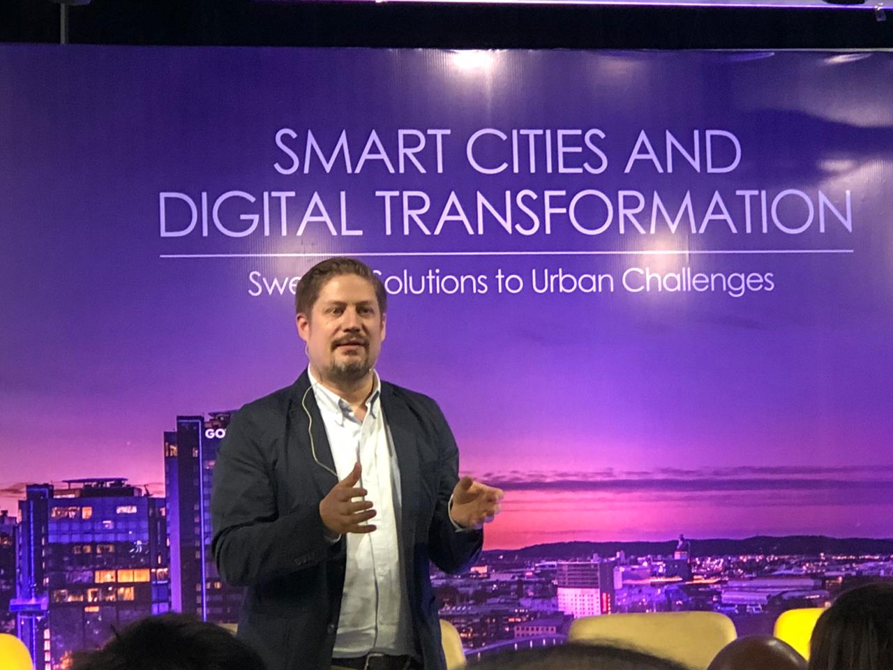Oskar Andermo på scen framför en bakgrund om smarta städer och digital omställning.