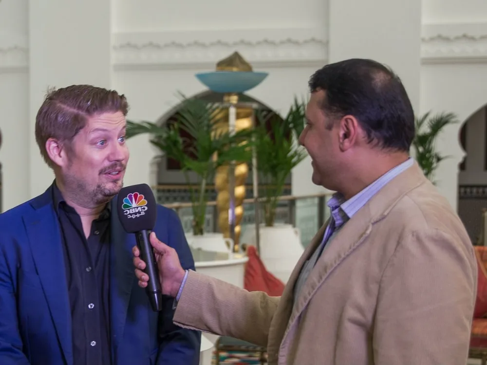 Oskar Andermo being interviewed with a microphone by a reporter in a hotel lobby